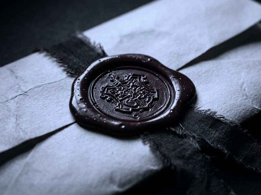 A heavy mechanical date stamp resting on a thick stack of carbon copy forms.