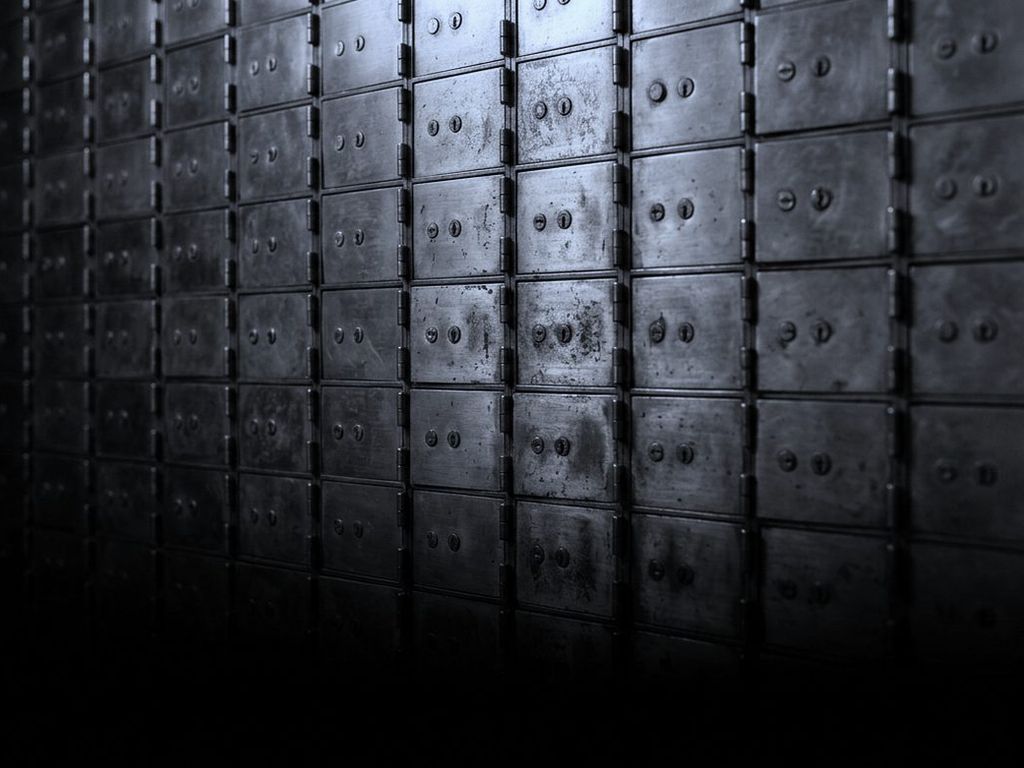 A wall of small brass safe deposit doors set in a dense grid.