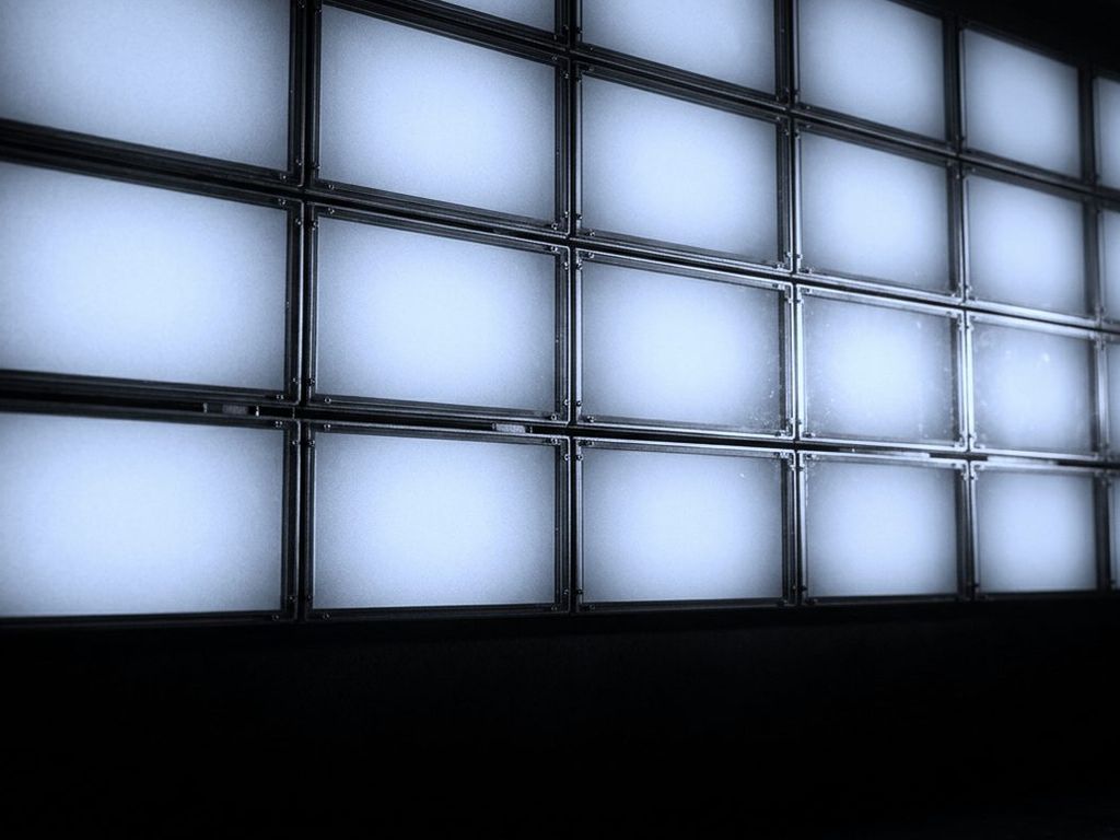 A wall of blank illuminated imaging panels, lit and empty, in a grid.