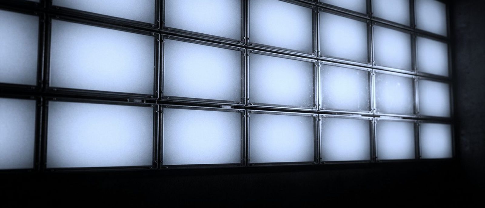 A wall of blank illuminated imaging panels, lit and empty, in a grid.