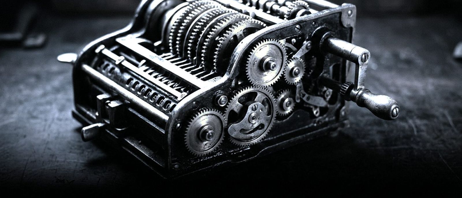 A hand-cranked mechanical calculator with its brass gears exposed.