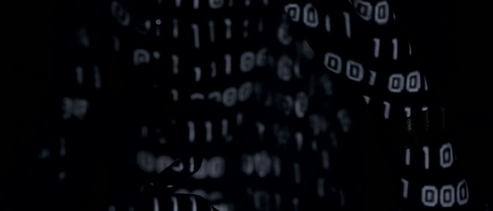 A figure obscured behind a projected wall of shifting digits.